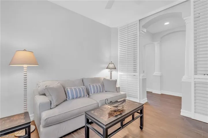 Living room featuring hardwood / wood-style floors, ceiling fan, and ornate columns