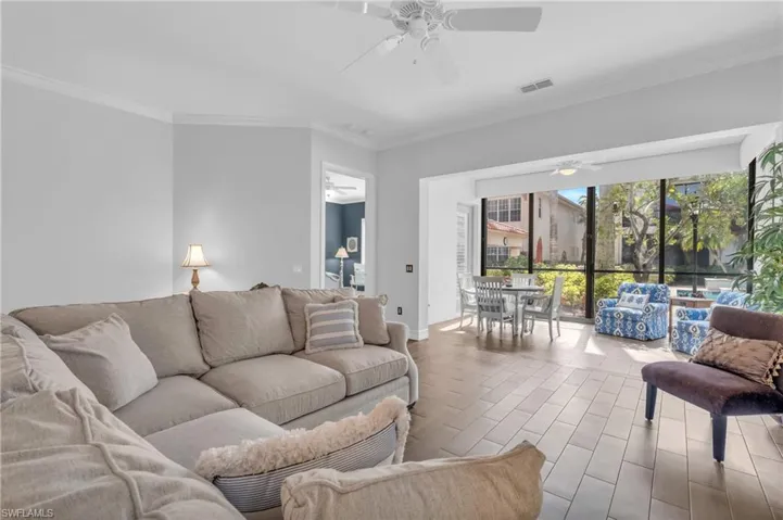 Living room featuring ceiling fan, ornamental molding, and light hardwood / wood-style flooring