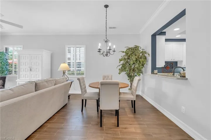 Dining area featuring ornamental molding and ceiling fan with notable chandelier