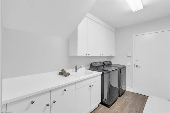 Washroom with cabinets, sink, and independent washer and dryer