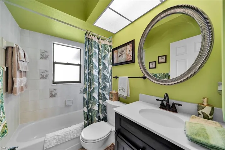 Full bathroom with vanity, toilet, and shower / bath combination with curtain