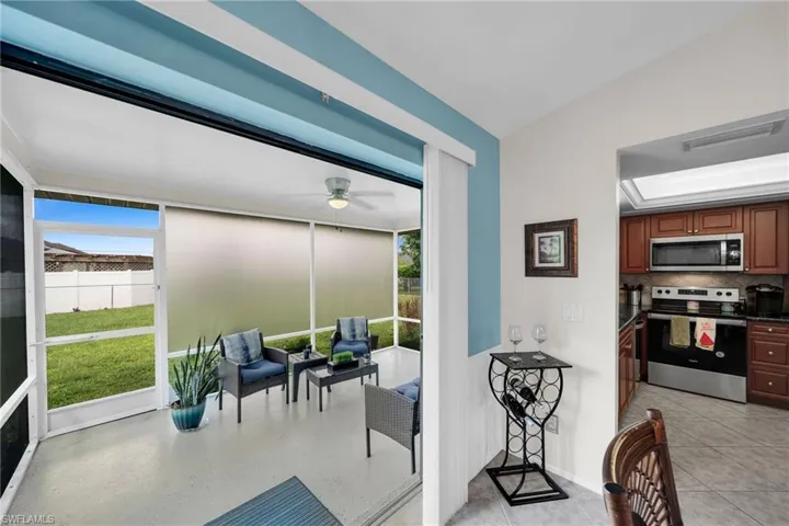 Kitchen featuring decorative backsplash, ceiling fan, appliances with stainless steel finishes, and light tile patterned floors
