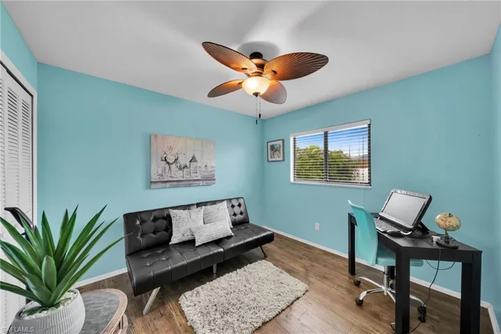 Home office with hardwood / wood-style floors and ceiling fan