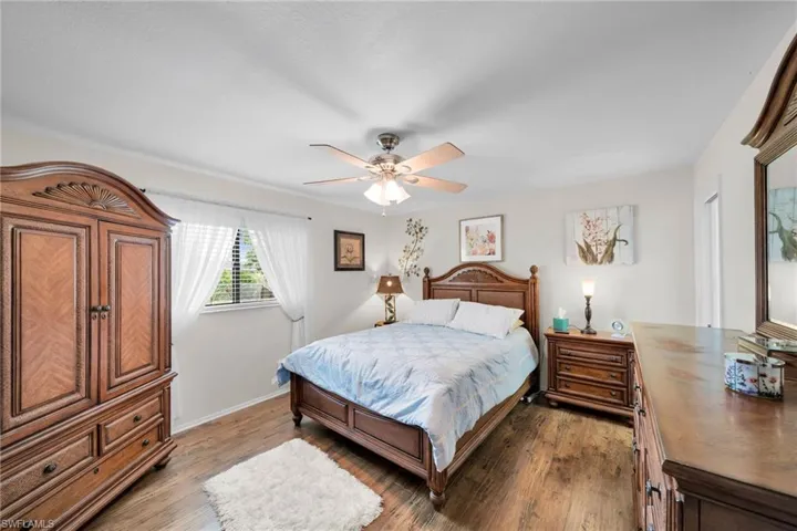 Bedroom featuring ceiling fan and dark hardwood / wood-style flooring