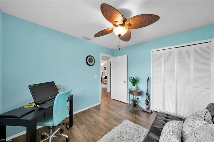 Home office featuring ceiling fan and dark wood-type flooring
