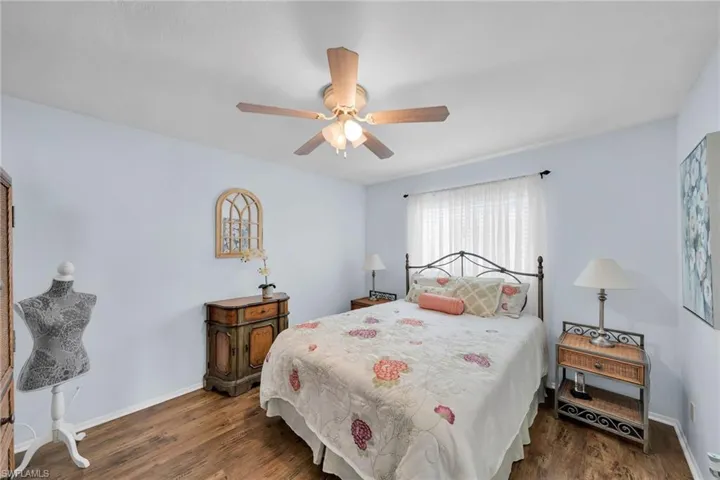 Bedroom with ceiling fan and dark hardwood / wood-style flooring
