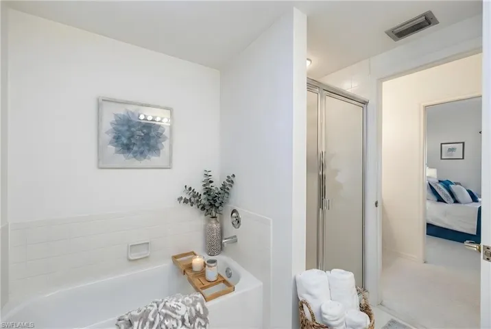 Ensuite bathroom featuring a shower stall and a garden tub
