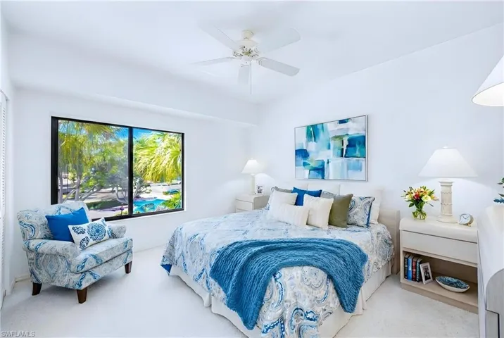Carpeted bedroom featuring a ceiling fan