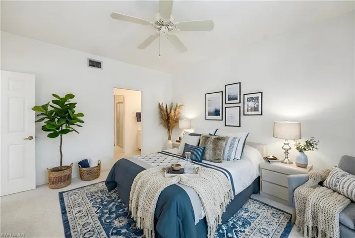 Carpeted bedroom with a ceiling fan and ensuite bath