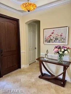 Foyer entrance with ornamental molding and arched walkways