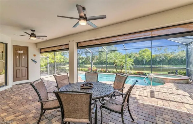 View of patio / terrace with ceiling fan, a pool with connected hot tub, and a lanai