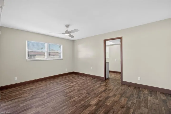 Empty room featuring dark wood-style floors and ceiling fan