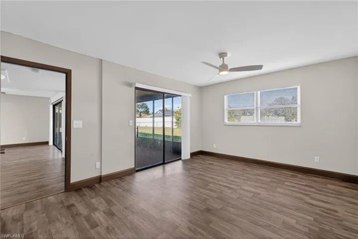 Spare room with dark wood finished floors and a ceiling fan
