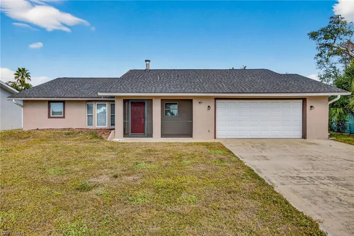 Single story home with stucco siding, a shingled roof, a front yard, and concrete driveway