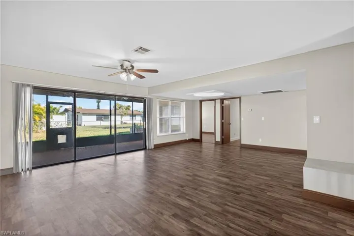 Unfurnished room featuring dark wood-type flooring and ceiling fan