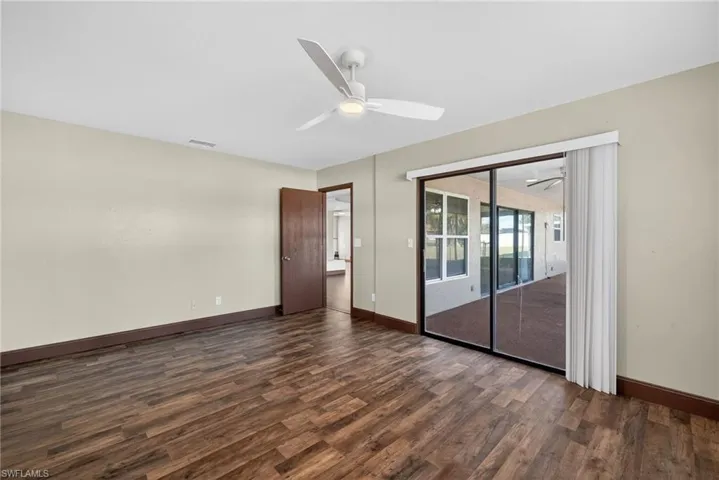 Unfurnished room with dark wood-type flooring and a ceiling fan
