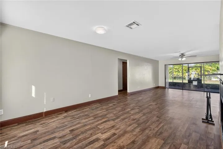 Empty room featuring a ceiling fan and dark wood finished floors
