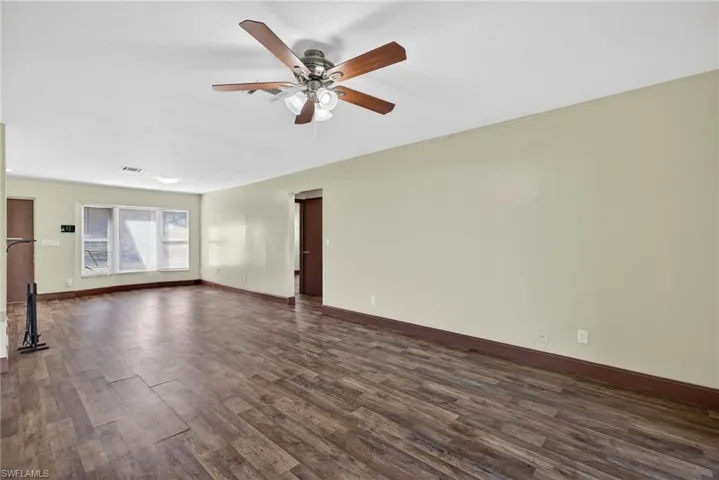 Empty room featuring dark wood finished floors and ceiling fan