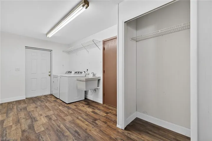 Laundry room featuring dark wood-style flooring and independent washer and dryer