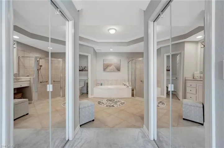 Full bathroom featuring independent shower and bath, toilet, vanity, ornamental molding, and tile patterned flooring