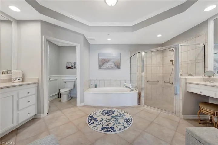 Full bathroom with independent shower and bath, toilet, vanity, ornamental molding, and tile patterned flooring