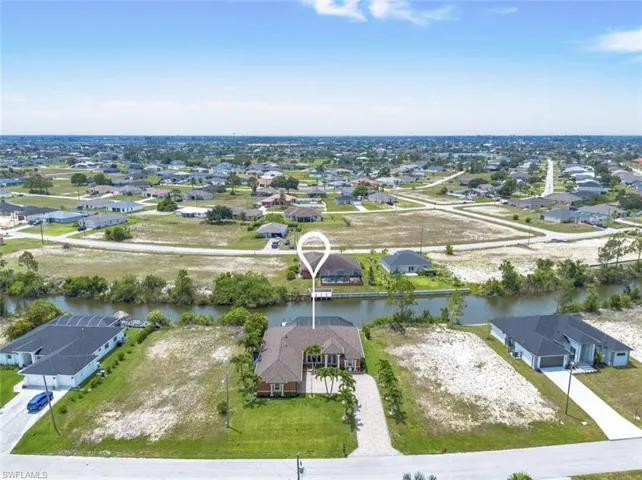 Birds eye view of property with a water view