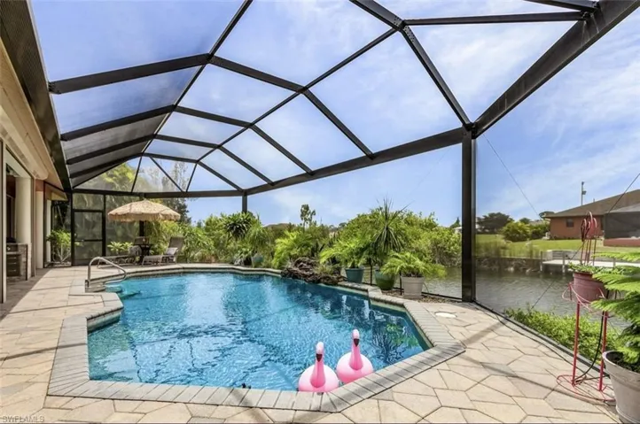 View of swimming pool featuring a patio area, a lanai, and a water view
