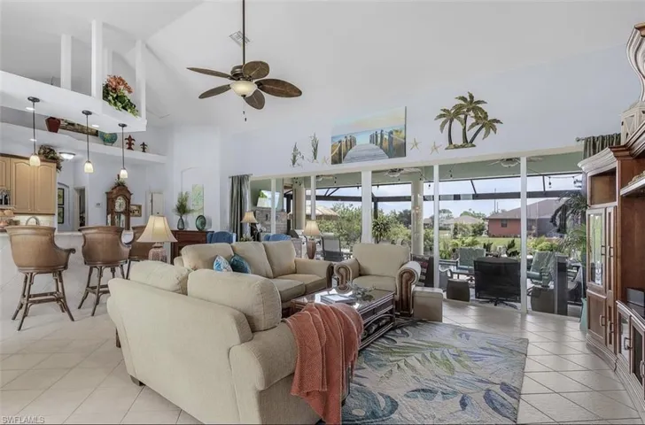 Tiled living room featuring high vaulted ceiling and ceiling fan
