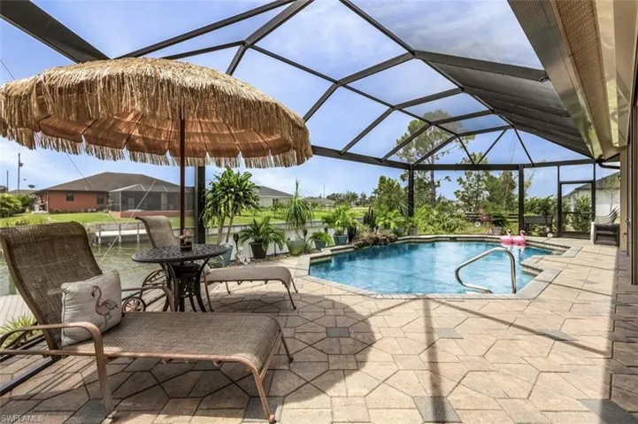 View of pool featuring a patio and glass enclosure