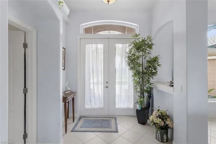 Foyer entrance with french doors and light tile patterned flooring