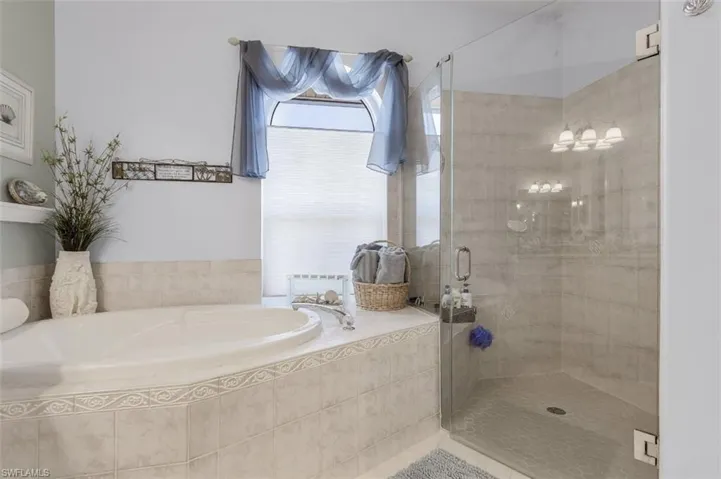 Bathroom featuring plus walk in shower and tile patterned flooring