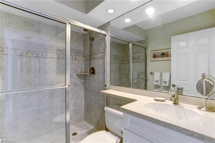 Guest bath with raised vanities, corian counters, custom tiles shower.