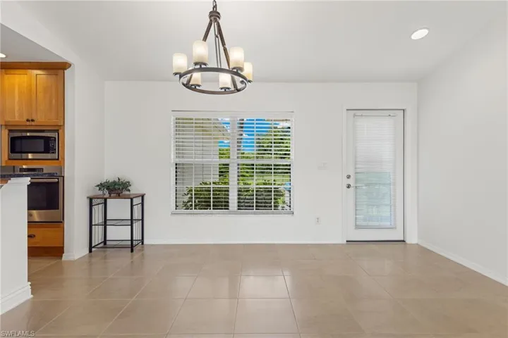 Dining area with an inviting chandelier and light tile floors