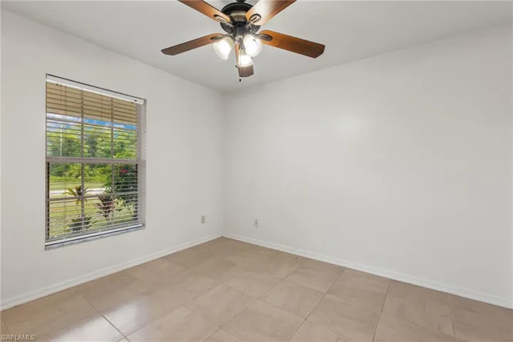 Tiled empty room with ceiling fan