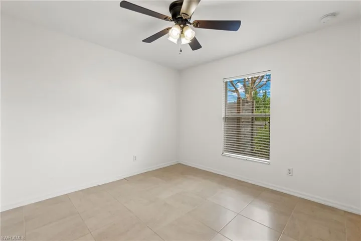 Tiled empty room featuring ceiling fan