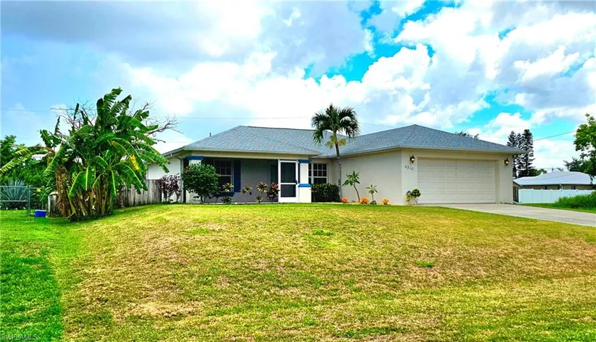 Ranch-style house featuring a garage and a front yard