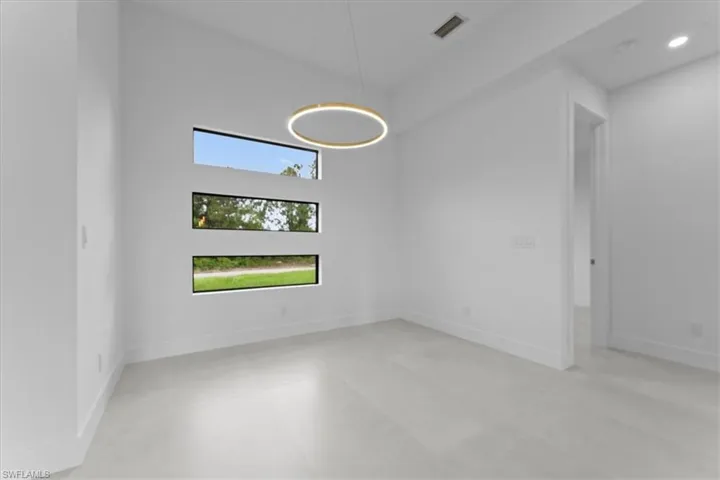 Empty room with a high ceiling and baseboards