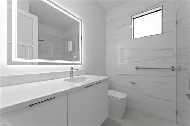 Full bathroom featuring vanity and a marble finish shower