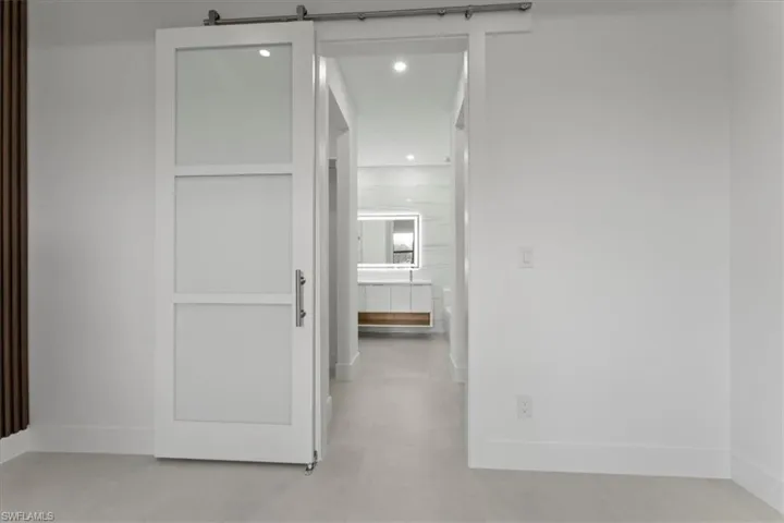 Hallway with a barn door and recessed lighting