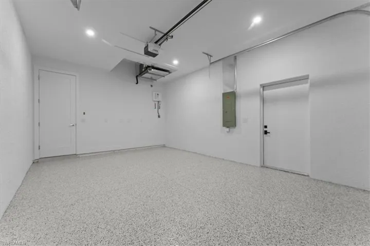 Garage featuring electric panel and recessed lighting