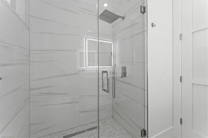 Bathroom with a marble finish shower