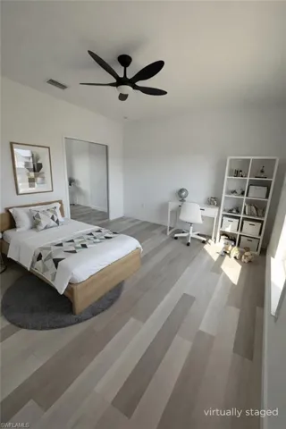 Bedroom featuring light wood-style floors, ceiling fan, and a closet