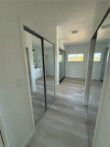 Hallway with a textured ceiling and light wood-style floors