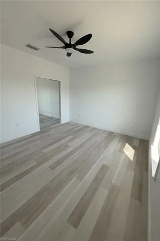 Unfurnished bedroom with light wood finished floors, ceiling fan, and a closet