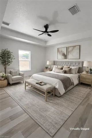 Bedroom featuring light wood finished floors, ceiling fan, and a textured ceiling