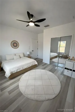 Bedroom featuring light wood-type flooring, a ceiling fan, and a closet