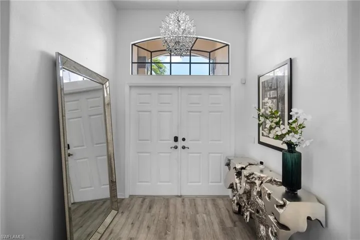 Foyer featuring a high ceiling, hardwood / wood-style floors, and an inviting chandelier