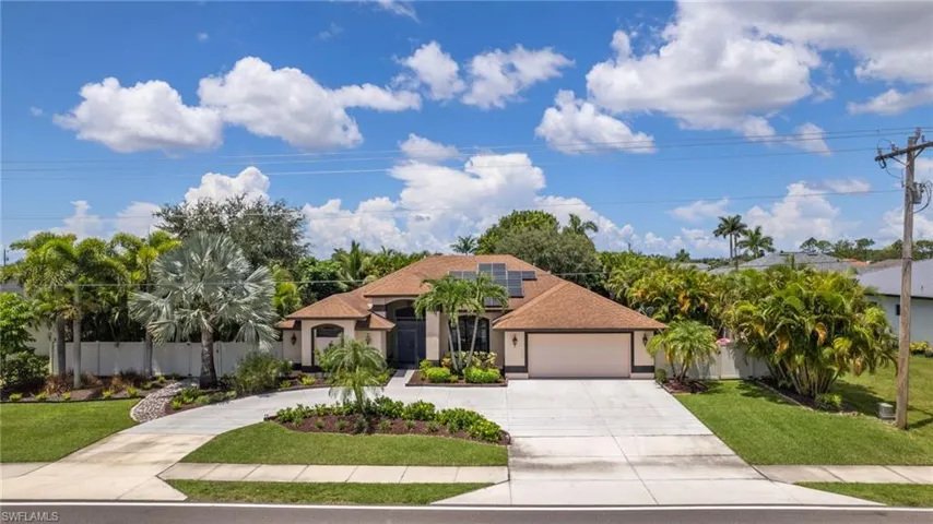 Mediterranean / spanish-style home featuring a front yard, a garage, and solar panels