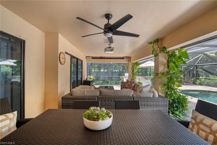 View of patio featuring an outdoor living space, ceiling fan, and a lanai