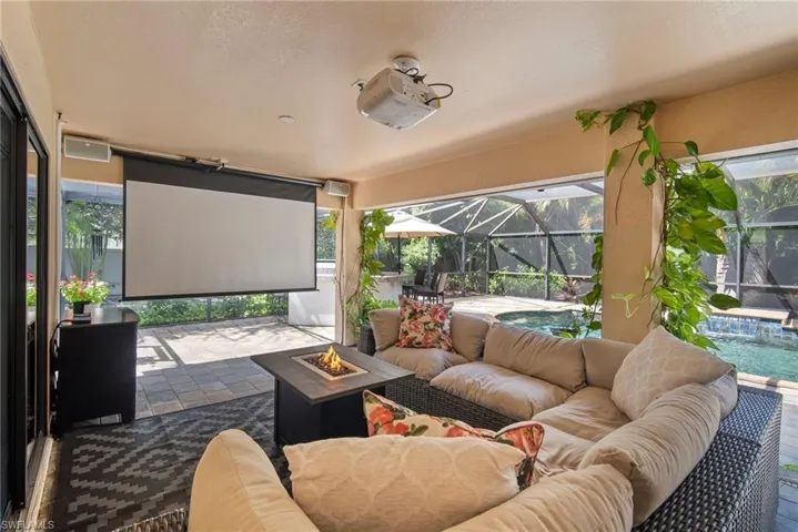 View of patio / terrace with an outdoor living space with a fire pit, pool water feature, and a lanai